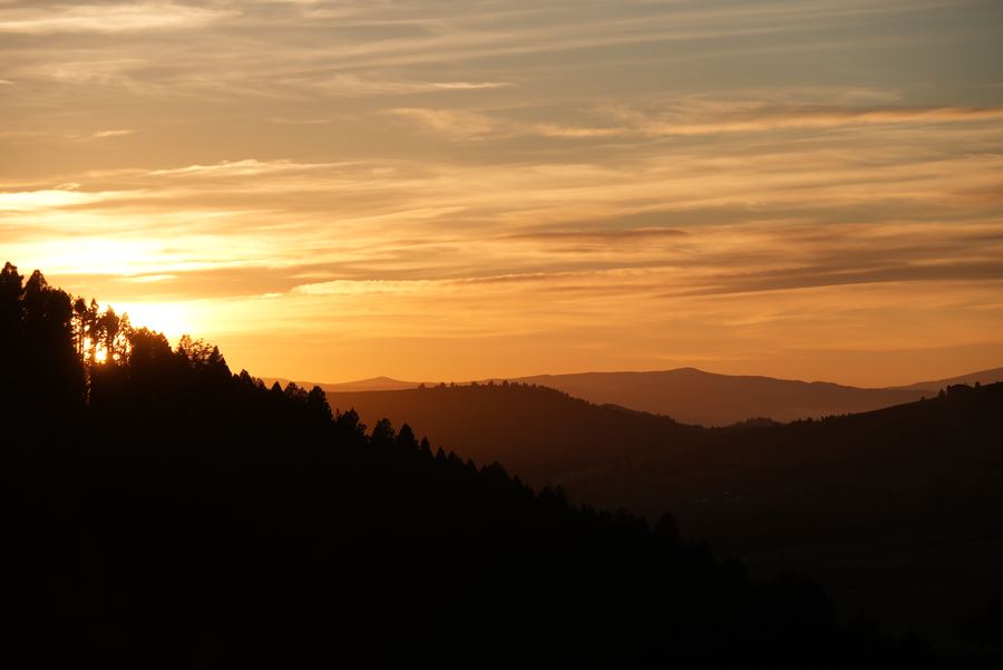 Layered ridgelines silhouetted against a golden sunset